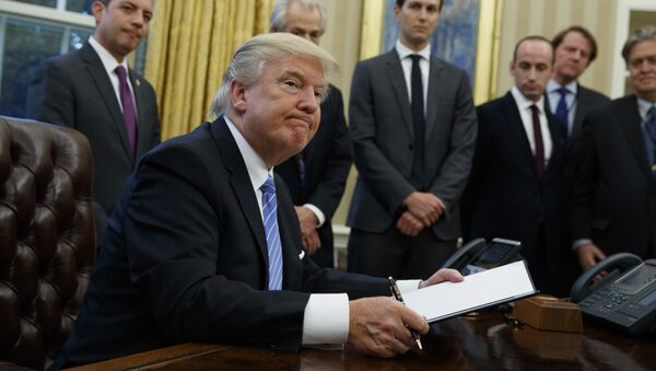 President Donald Trump looks up after signing the final of three executive orders, Monday, Jan. 23, 2017, in the Oval Office of the White House in Washington. (AP Photo/Evan Vucci) - Sputnik Türkiye