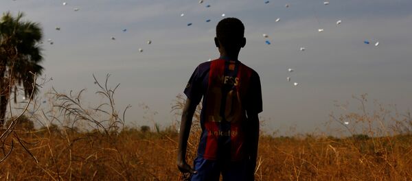 Güney Sudan'da BM Dünya Gıda Programı'nın havadan attığı gıda yardımlarını izleyen bir çocuk - Sputnik Türkiye