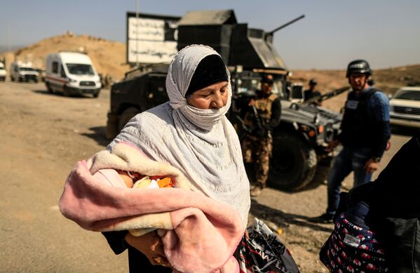 Musul'da çocuğuyla birlikte evini terk eden bir anne. - Sputnik Türkiye