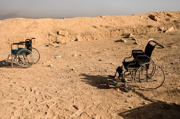 Musul'da çatışmaların sürdüğü bölgede terk edilen tekerlekli sandalyeler. - Sputnik Türkiye