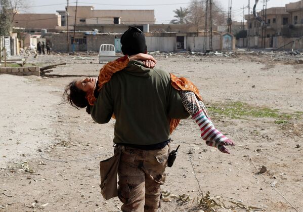 Iraklı asker, Musul’daki askeri operasyonda yaralanan bir kız çocuğunu taşıyor. - Sputnik Türkiye