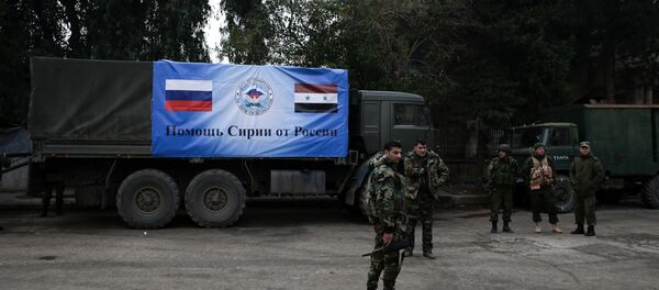 Russian and Syrian soldiers stand next to an aid convoy in Aleppo, Syria, Sunday, Dec. 4, 2016 - Sputnik Türkiye