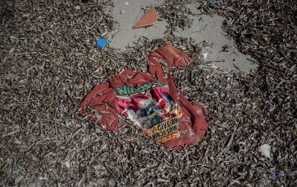 Dikili plajlarında sığınmacıların geride bıraktığı giysiler, eşyalar, can yelekleri, pompa ambalajları ve patlak lastik botlar bulunuyor - Sputnik Türkiye