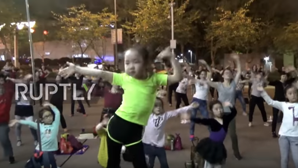 Çin’in Çongçing kentinde ‘dansçı teyze’ olarak anılan 5 yaşındaki Dailan Jingyi’nin yetişkinlerden oluşan dansçı kalabalığı yönettiği anlar kameraya yansıdı. - Sputnik Türkiye