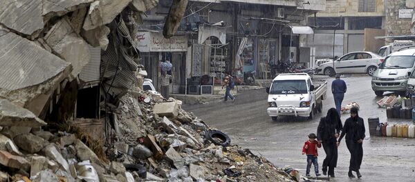 Civilians walk in the rain past a damaged building in the rebel-controlled area of Maaret al-Numan town in Idlib province, Syria October 28, 2015 - Sputnik Türkiye