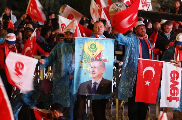 Alandaki bazı vatandaşların bozkurt işareti yaptığı, bazılarının ise üzerinde 'Osmanlı arması' ve Recep Tayyip Erdoğan'ın fotoğrafının yer aldığı bayraklar taşıdığı görüldü. - Sputnik Türkiye