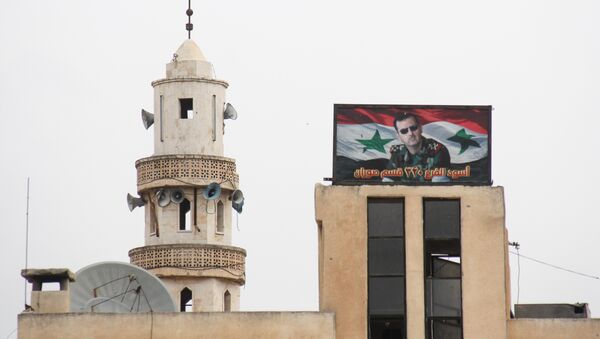 Hama'ya bağlı Suran kasabasında bir caminin yanında bulunan Suriye Devlet Başkanı Beşar Esad'ın fotoğrafının yer aldığı pano - Sputnik Türkiye