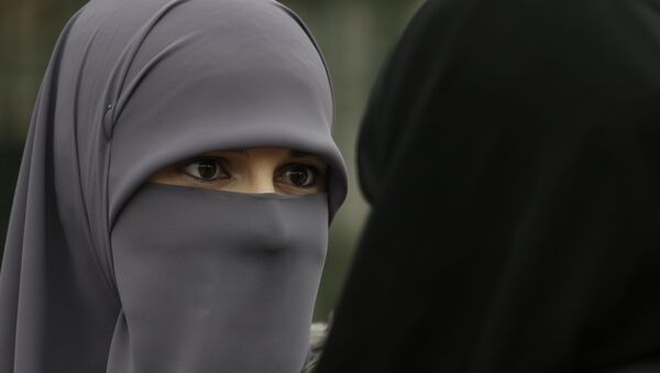 A Muslim woman talks with a friend during events to observe World Hijab Day, celebrating the veil traditionally worn by Muslim women - Sputnik Türkiye