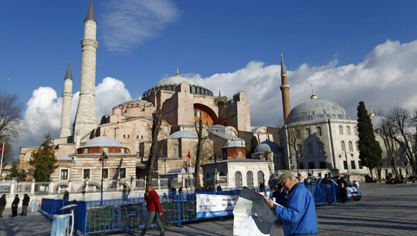 A tourist couple checks a map, near the Byzantine-era monument of Hagia Sophia, at Sultanahmet square in Istanbul,Turkey January 14, 2016 - Sputnik Türkiye