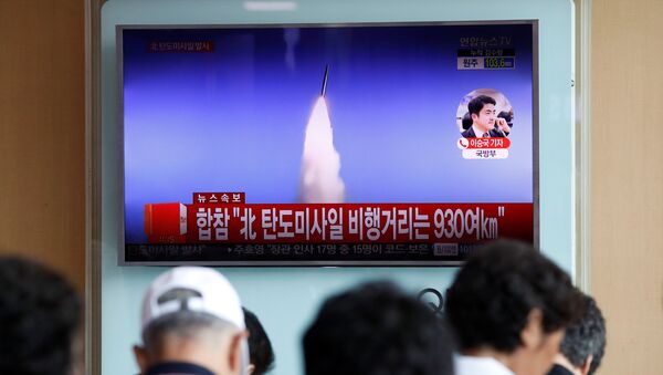 People watch a TV broadcast of a news report on North Korea's ballistic missile test, at a railway station in Seoul, South Korea, July 4, 2017. - Sputnik Türkiye
