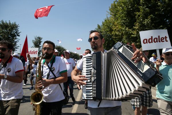Ellerinde Atatürk posterleri, Türk bayrakları, 'adalet' yazılı flamalar bulunan katılımcılar, etkinlik sırasında 'Hak, hukuk, adalet' şeklinde slogan attı. Yürüyüş sırasında vatandaşların taşıdığı dev Türk bayrağı da alanda açıldı. - Sputnik Türkiye