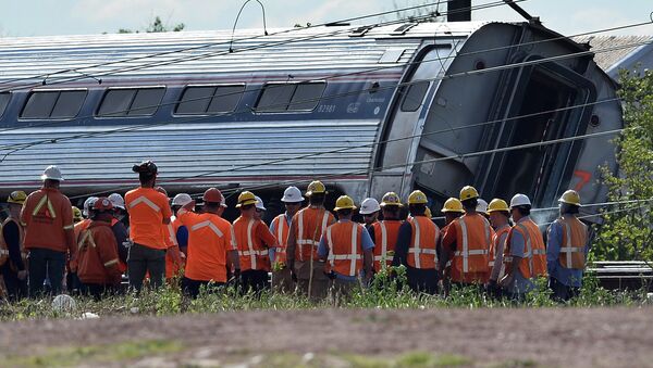 Rescuers gather around a derailed carriage of an Amtrak train in Philadelphia, Pennsylvania, on May 13, 2015 file photo - Sputnik Türkiye