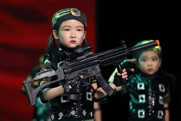 Pekin'de mezuniyet töreninde bir anaokulu öğrencisi. Kızın şapkasında Çin Halk Kurtuluş Ordusu logosu var. - Sputnik Türkiye