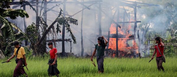 Arakan'da yanan bir evin etrafında dolaşan eli bıçaklı ve sapanlı kimli belirsiz kişiler - Sputnik Türkiye