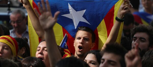 Eylemciler 'Oy kullanacağız', 'Merhaba demokrasi' sloganları atıp, 'Diktatörlüğü durdurun' pankartı taşıdı. Katalonya'nın bağımsızlığını savunan sivil toplum örgütleri İspanyol jandarmasının dün gerçekleştirdiği gözaltılar ve Katalan resmi kurumlarında yaptığı aramalara karşı uzun süreli protesto gösterileri düzenlenmesi çağrısında bulunmuştu. - Sputnik Türkiye