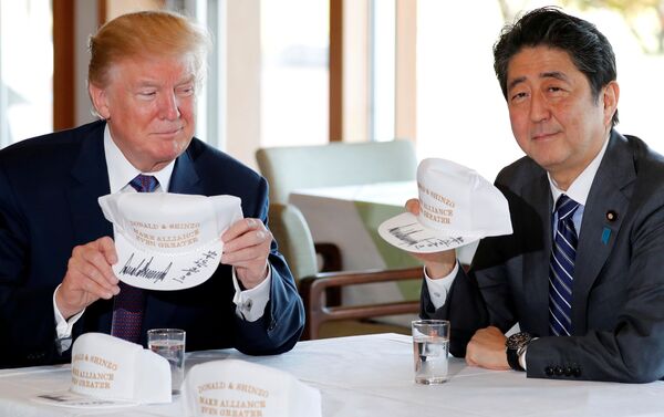 Trump ve Abe, üzerinde 'Donald & Şinzo, ittifakı daha da güçlü kılıyor' yazılı şapkaları imzaladı. - Sputnik Türkiye