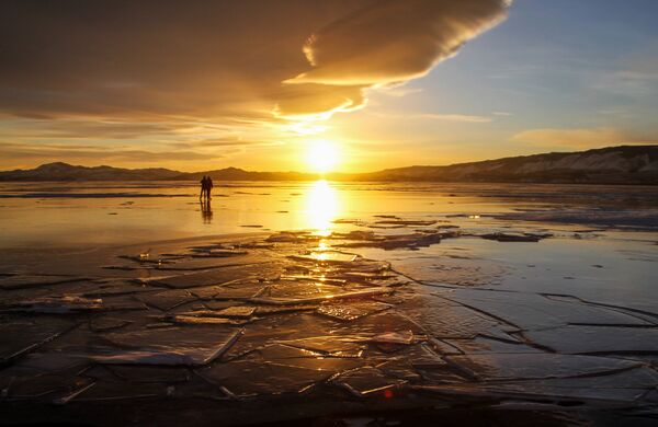 İnsanlar, donmuş Baykal Gölü'nün üzerinde dolaşıyor. - Sputnik Türkiye