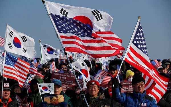 Kuzey Kore karşıtı Güney Koreli göstericiler ise ellerindeki Güney Kore ve ABD bayraklarıyla protesto düzenledi. - Sputnik Türkiye