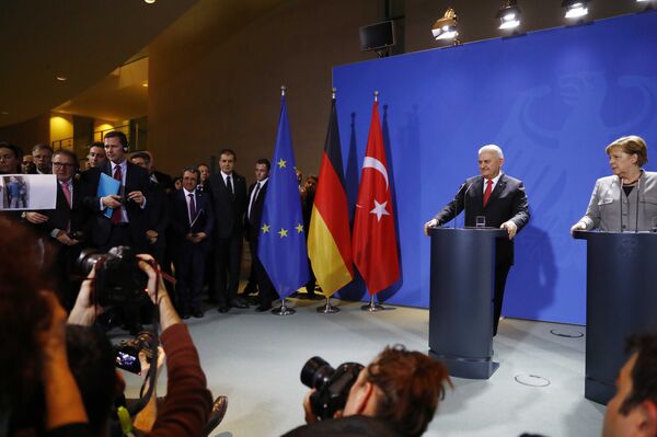 Merkel-Yıldırım basın toplantısında bir gazeteci Afrin'e ait olduğunu iddia ederek bazı fotoğraflar gösterdi. - Sputnik Türkiye