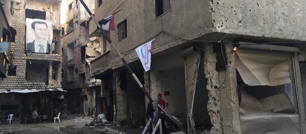 Şam'ın güneyindeki Yermuk'ta Suriye Devlet Başkanı Beşar Esad'In fotoğrafının yer aldığı afiş - Sputnik Türkiye