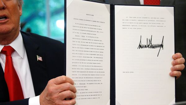 U.S. President Donald Trump displays an executive order on immigration policy after signing it in the Oval Office at the White House in Washington, U.S., June 20, 2018. - Sputnik Türkiye