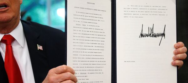 U.S. President Donald Trump displays an executive order on immigration policy after signing it in the Oval Office at the White House in Washington, U.S., June 20, 2018. - Sputnik Türkiye