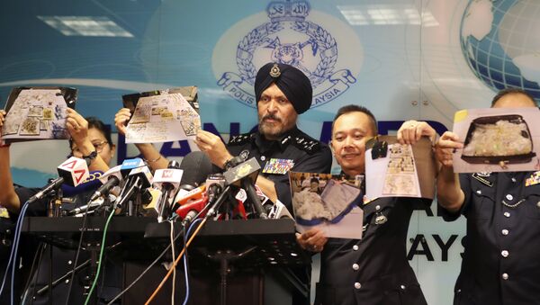 Malezya Emniyeti'nin Ticari Suçlarla Mücadele Şubesi Başkanı Amar Singh ile ekibi, eski Başbakan Necip Rezak ile bağlantılı evlerde ele geçirilen nakit para, mücevher ve diğer malların fotoğraflarını gösterdi. - Sputnik Türkiye