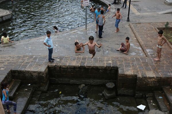 Diyarbakır'da sıcaktan bunalan çocuklar, süs havuzlarına girerek serinliyor. - Sputnik Türkiye