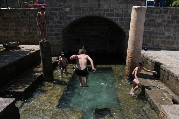 Diyarbakır'da sıcaktan bunalan çocuklar, süs havuzlarına girerek serinliyor. - Sputnik Türkiye