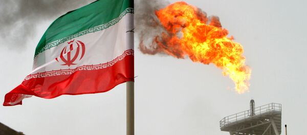 A gas flare on an oil production platform in the Soroush oil fields is seen alongside an Iranian flag in the Persian Gulf, Iran, July 25, 2005 - Sputnik Türkiye