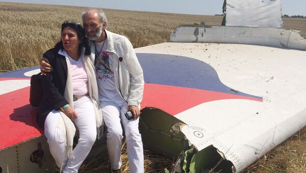 Jerzy Dyczynski and Angela Rudhart-Dyczynski whose daughter, 25-year-old Fatima, was a passenger on Malaysia Airlines flight MH17, sit on part of the wreckage of the crashed aircraft in Hrabove, Ukraine, Saturday, July 26, 2014 - Sputnik Türkiye
