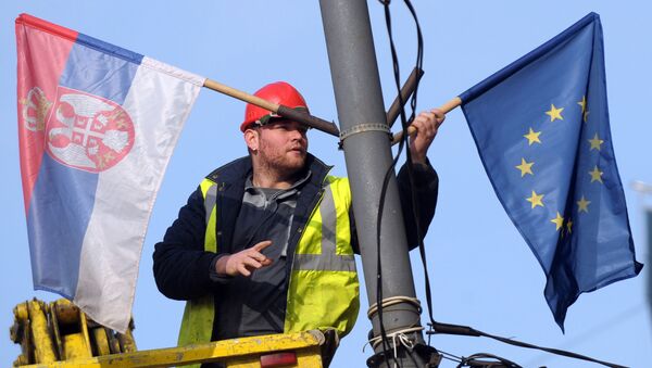 A worker arranges flags of Serbia and EU on a lamppost in Belgrade (File) - Sputnik Türkiye