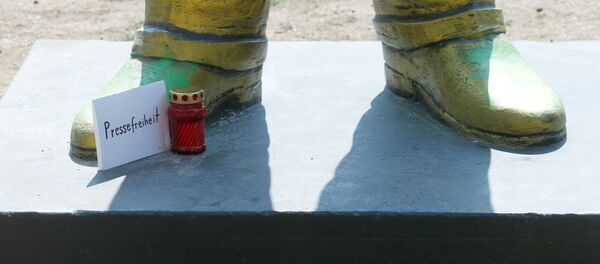 Almanya'nın Wiebaden kentinde daha sonra kaldırılan Erdoğan heykeline, protesto amacıyla, basın özgürlüğü yazılı kartla hapisteki gazeteciler ve muhalifler için mum bırakanlar da oldu. - Sputnik Türkiye