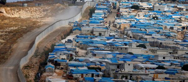 Suriye'nin İdlib vilayetinin Atameh kasabasını Türkiye sınırından bir duvar ayırıyor. - Sputnik Türkiye