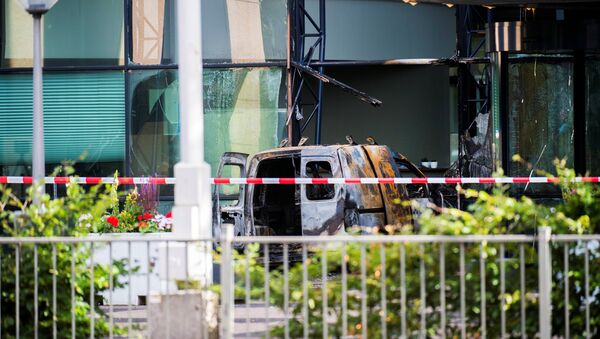 A van is seen burned out after crashing into the glass facade of the head office of Dutch newspaper De Telegraaf in what police said was a deliberate action in Amsterdam, Netherlands June 26, 2018 - Sputnik Türkiye