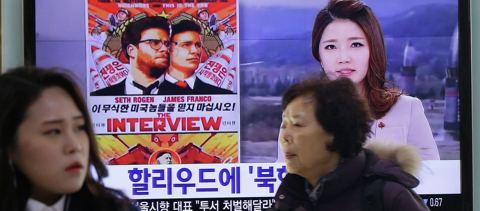 People walk past a TV screen showing a poster of Sony Picture's The Interview in a news report, at the Seoul Railway Station in Seoul, South Korea, Monday, Dec. 22, 2014 - Sputnik Türkiye, 1920, 06.09.2018