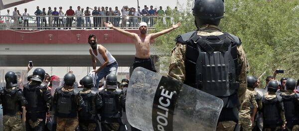 Police prevent protesters from storming the provincial council building during a demonstration in Basra, Iraq, 340 miles (550 kilometers) southeast of Baghdad, on Sunday, July 15, 2018 - Sputnik Türkiye
