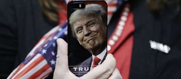 In this Thursday, Sept. 29, 2016, file photo, a woman holds up her cell phone before a rally with then presidential candidate Donald Trump in Bedford, N.H. - Sputnik Türkiye