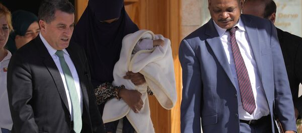 DSG Dış İlişkiler Sorumlusu Abdulkerim Omar (solda), IŞİD mensubu Sudanlı bir kadın ile bir aylık bebeğini, Sudanlı bir diplomata teslim etti. - Sputnik Türkiye