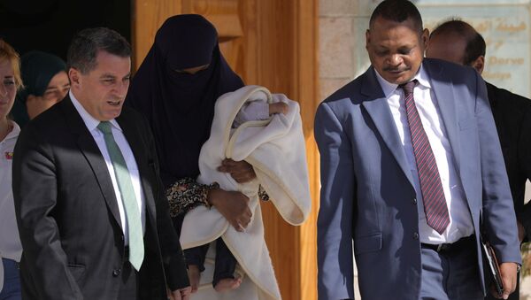 DSG Dış İlişkiler Sorumlusu Abdulkerim Omar (solda), IŞİD mensubu Sudanlı bir kadın ile bir aylık bebeğini, Sudanlı bir diplomata teslim etti. - Sputnik Türkiye