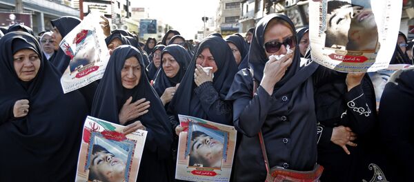 Ahvaz'daki cenaze töreninde Devrim Muhafızları kendi mensuplarının tabutlarını ve fotoğraflarını taşırken gözüyaşlı kadınlar da saldırının 4 yaşındaki kurbanı Muhammad Taha Eghdami'nin fotoğrafını açtı. - Sputnik Türkiye