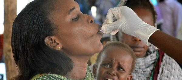 A woman swallows an oral cholera vaccine given to her by an MSF (Doctors without Borders) doctor, in Juba on July 31, 2015, as part of a vaccination campaign provided by MSF. - Sputnik Türkiye
