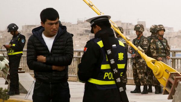 Çin'in Sincan Uygur Özerk Bölgesi'nde polis kimlik denetimi yapıyor. - Sputnik Türkiye