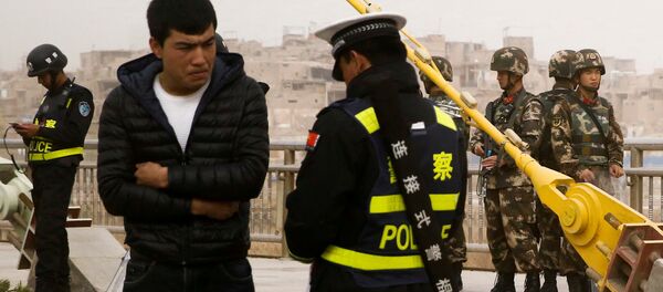 Çin'in Sincan Uygur Özerk Bölgesi'nde polis kimlik denetimi yapıyor. - Sputnik Türkiye