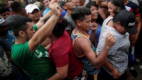 Orta Amerika ülkelerinden ABD'ye doğru harekete geçen binlerce kişilik göçmen kafilesi, 24 Ekim'de Meksika'nın Mapastepec kentinde dans ederken - Sputnik Türkiye