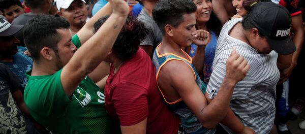 Orta Amerika ülkelerinden ABD'ye doğru harekete geçen binlerce kişilik göçmen kafilesi, 24 Ekim'de Meksika'nın Mapastepec kentinde dans ederken - Sputnik Türkiye