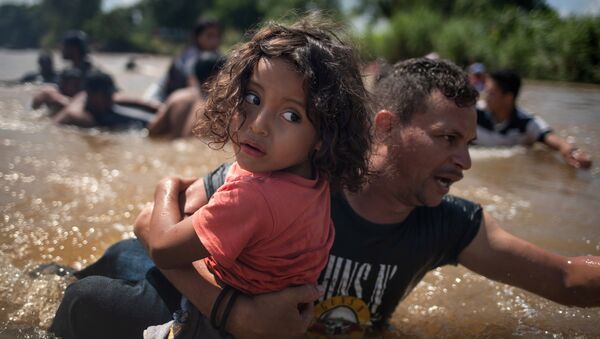 Orta Amerika'dan göçmenler, kafileler halinde Meksika'ya yöneliyor ve ABD'ye doğru ilerliyor. 29 Ekim 2018'de Suchiate Nehri'nin tehlikeki sularından çocuklarıyla birlikte geçen göçmenler, Guatemala'dan Meksika'ya giriş yaptı. - Sputnik Türkiye