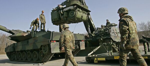 The crew of a 'Buffalo' wrecker tank, right, of the German Army lifts the engine of a Leopard 2 battle tank, left, for repair during a demonstration at the Bayern Barracks in Munich, southern Germany, on Wednesday, Feb. 20, 2008 - Sputnik Türkiye