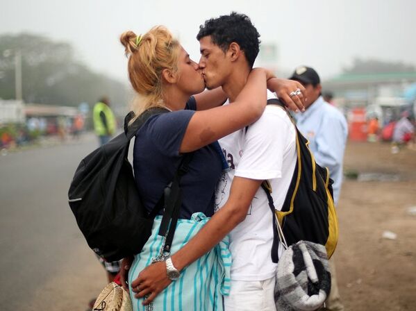 Göçmen konvoyundaki 17 yaşındaki Isabel Arguete ile 21 yaşındaki Not Muez yol kenarında öpüşüyor. - Sputnik Türkiye