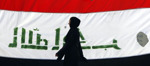 An Iraqi woman walks her national flag during a celebration marking the the departure of US troops from Iraq in Baghdad's Adhamiyah neighbourhood. File photo - Sputnik Türkiye